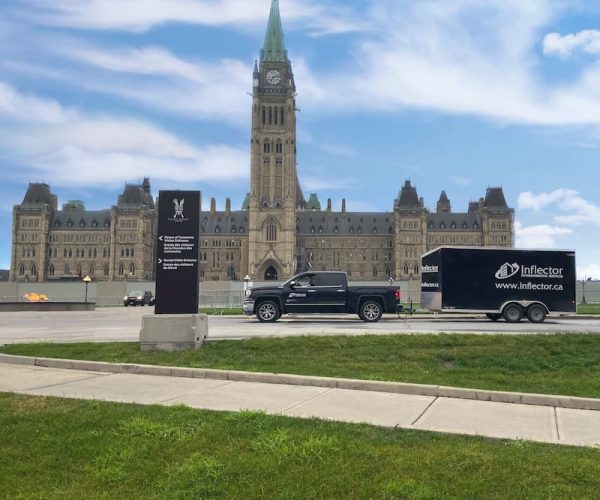 Inflector truck and trailer parked outside of parlement building